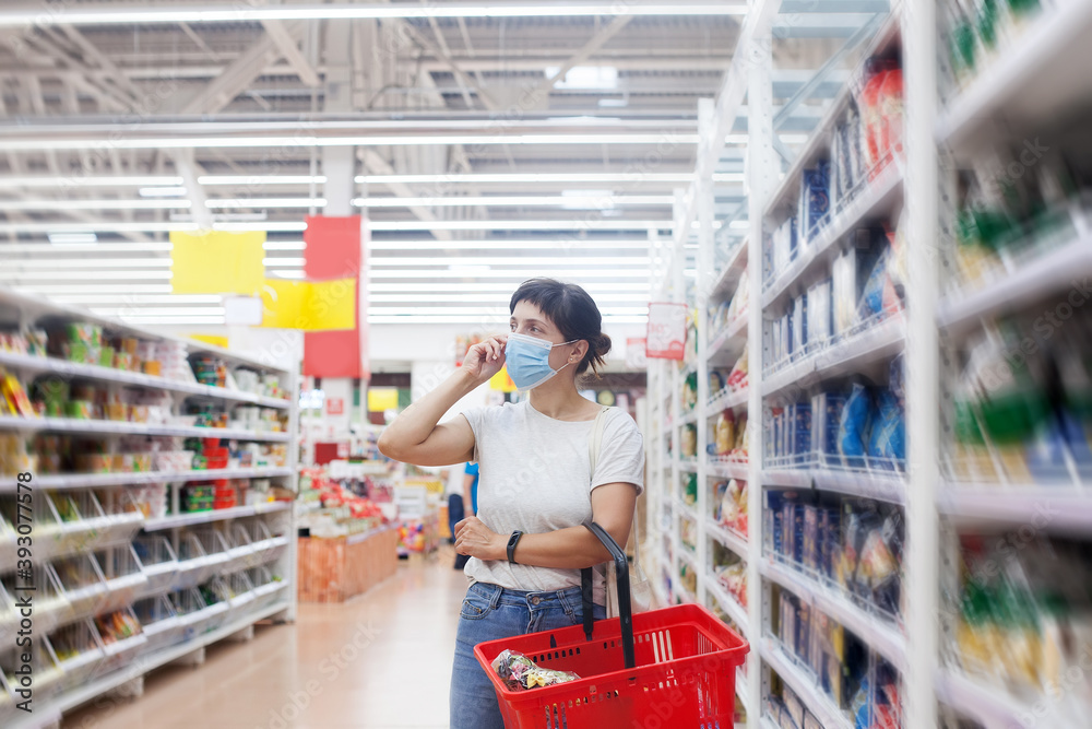 woman with face mask walking through grocery store