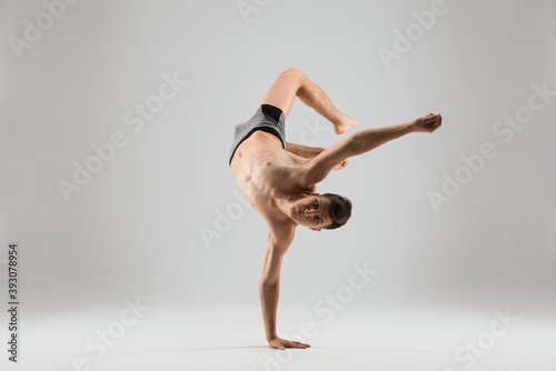 Flexible man dancing breakdance on one hand