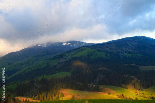 Cloudy morning spring rural landscape in the Carpathian mountains. Dramatic sky before dawn.