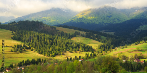 Spring morning rural landscape in the Carpathian mountains. Low clouds are on the tops of mountains.