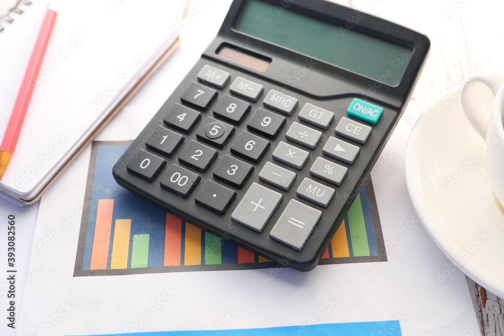 Close up of blue calculator and notepad on color background Close up of blue calculator and notepad on color background