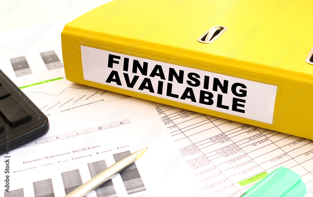 The yellow document folder is on the office desk. Nearby a calculator, finance graphs. The yellow document folder is on the office desk. Nearby a calculator, finance graphs.