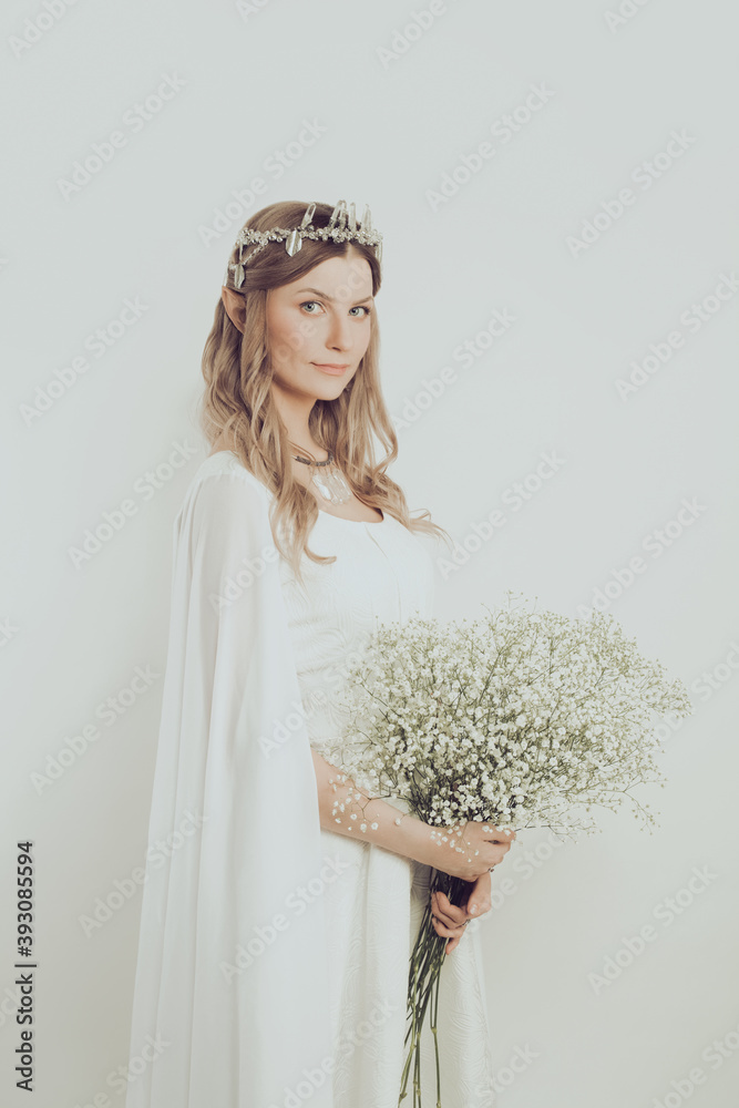 Elegant pretty woman elf with white flowers. Mysterious elven sorceress halloween character costume Elegant pretty woman elf with white flowers. Mysterious elven sorceress halloween character costume