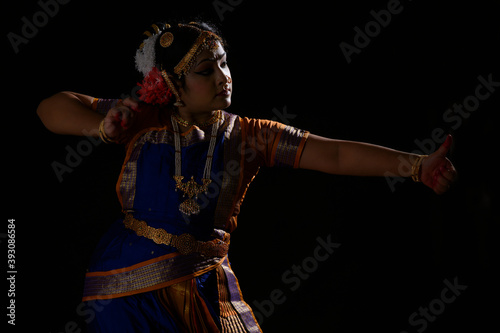 Kuchipudi dancer portraying an Archer holding a bow and arrow in her dance performance	 photo
