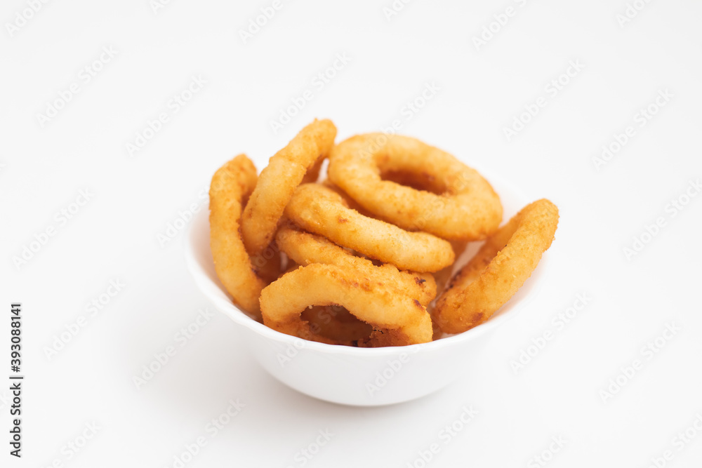Portion of fried onion rings in a white bowl isolated on a white background Portion of fried onion rings in a white bowl isolated on a white background