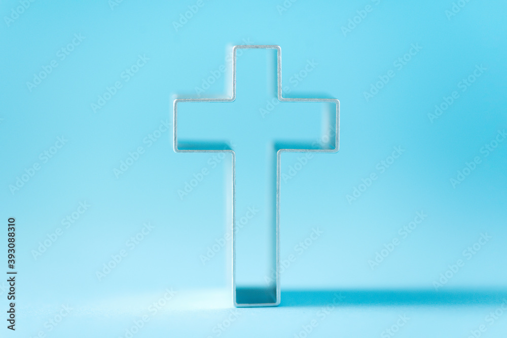 Obraz premium Christian cross on blue background with soft bokeh lights background. Copy space. Banner. Church worship, salvation concept. Faith symbol in Jesus Christ. Holy cross for good friday, Easter day