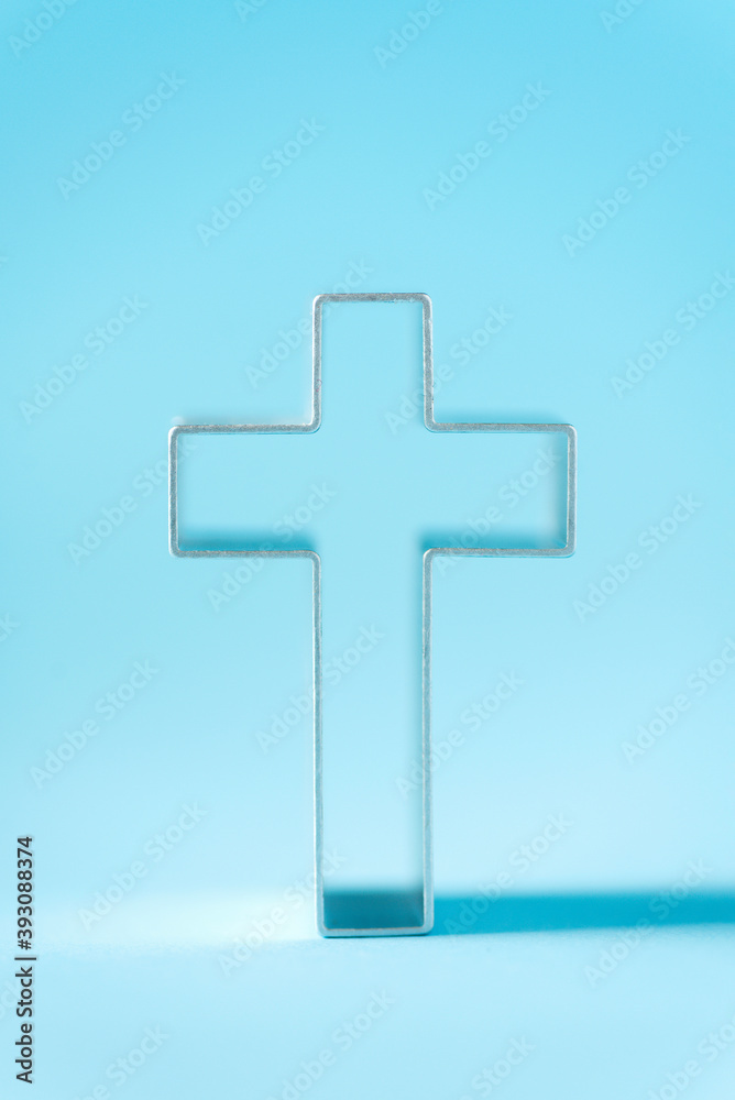 Obraz premium Christian cross on blue background with soft bokeh lights background. Copy space. Banner. Church worship, salvation concept. Faith symbol in Jesus Christ. Holy cross for good friday, Easter day