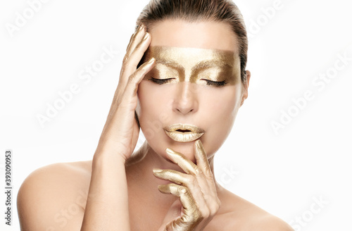Gold based anti aging skincare concept. Beautiful model woman with gold treatment on a flawless skin