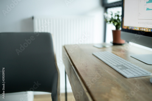 eleganckie drewniane biurko, home office, komputer z białą klawiaturą  © sandrqa