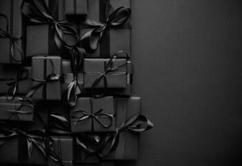 A pile various size black boxed gifts placed on stack. Christmas concept.