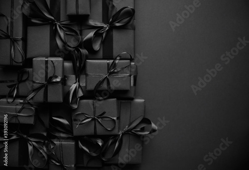 A pile various size black boxed gifts placed on stack. Christmas concept.