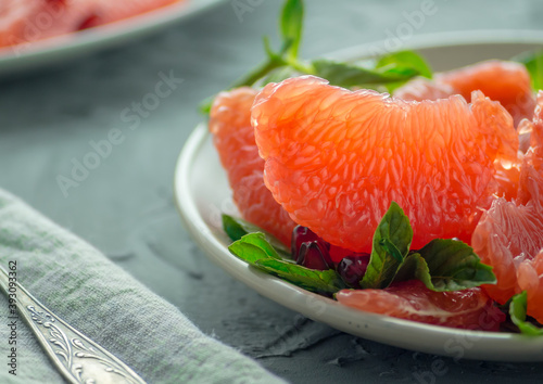 Grapefruit slices with mint leaves, sprinkled with pomegranate.