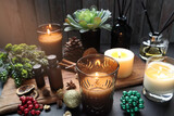 aromatic scented candle glass , reed diffuser and essential oil are in wooden tray on black wooden table with dried flowers , herbs, ornaments and spices pinecone in the living room during Christmas