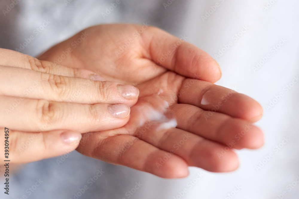 A woman moisturizes dry skin with a cream. A woman moisturizes dry skin with a cream.