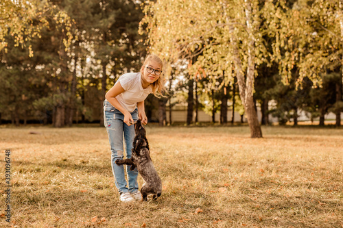 Canvastavla Teenager blonde girl with big glasses laughing and playing with little puppy spa