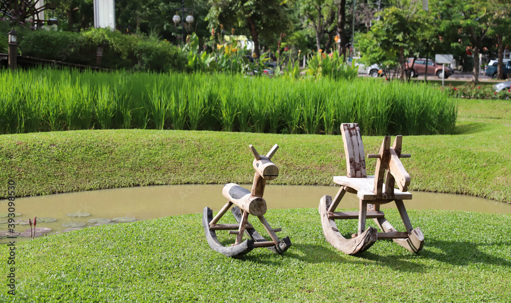 Fototapeta premium Closeup of traditional wooden toy chairs on green lawn.