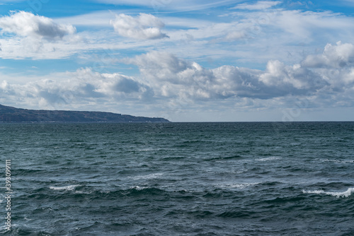 白波が打ち付ける青空の海岸と地平線