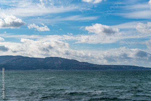 白波が打ち付ける青空の海岸と地平線 © 健 吉田