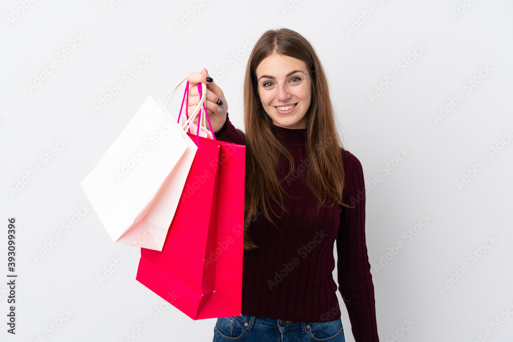 Young woman over isolated white background holding shopping bags and giving them to someone