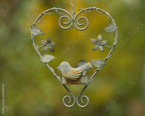 Heart of flowers and bird iron pendant with an autumn color background, this vintage photo I made on 17 november 2020 in Weert the Netherlands  photo