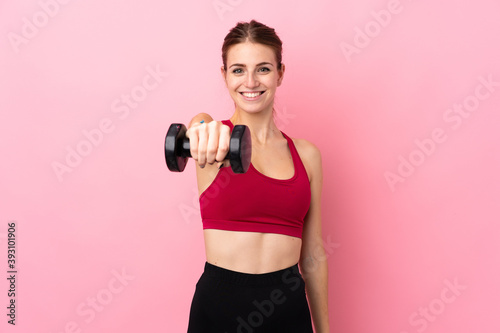 Young sport woman over isolated pink background making weightlifting