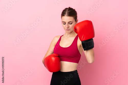 Young sport woman over isolated pink background with boxing gloves © luismolinero