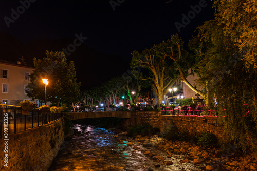 A picturesque view of a small mountain river flowing through a French medieval alpine village at night (Puget-Theniers, Alpes-Maritimes, Provence-Alpes-Cote-d'Azur, France)