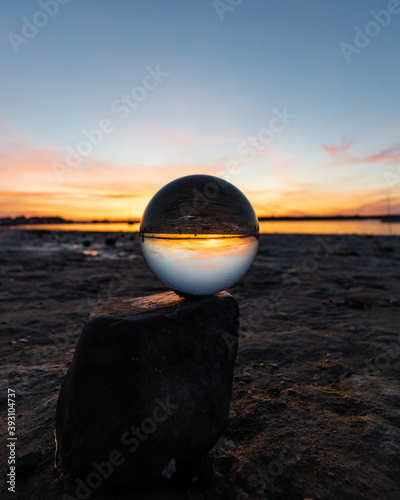 Beautiful sunset captured through a lens ball at the coastline photo
