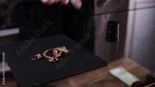 A woman brought gold rings and chainlets to a pawn shop for selling in close-up. An owner is appraising jewelry and paying cash to a lady. A man takes away all bijou Concept of buying precious metals. photo