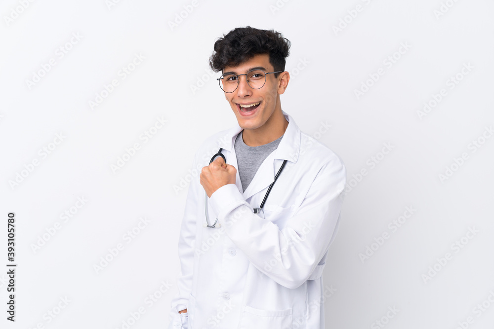 Young Argentinian man over isolated white background wearing a doctor gown and making victory gesture Young Argentinian man over isolated white background wearing a doctor gown and making victory gesture