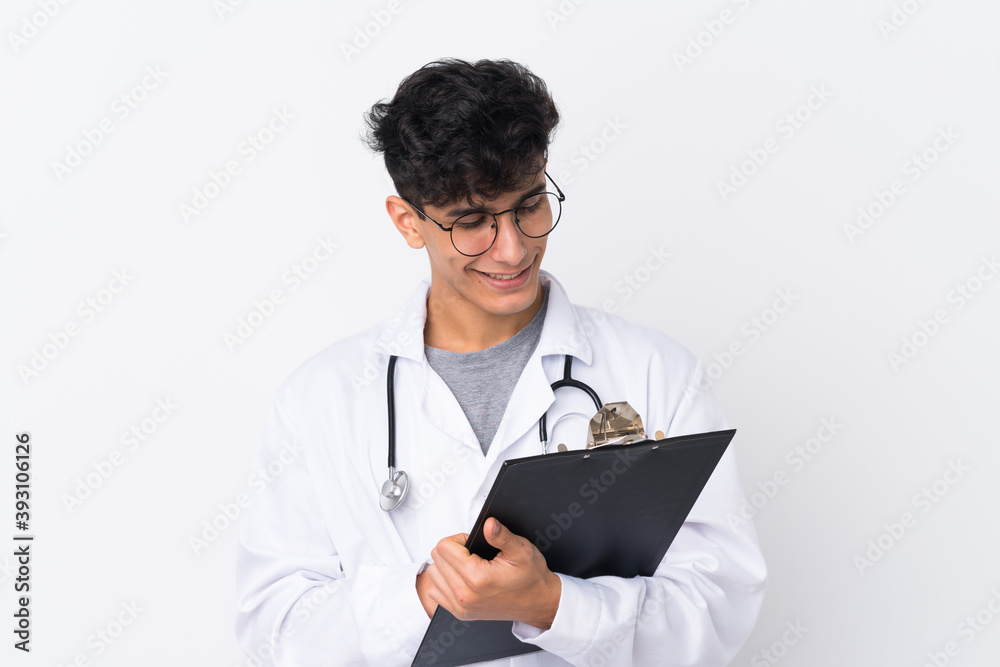 Young Argentinian man over isolated white background wearing a doctor gown and holding a folder Young Argentinian man over isolated white background wearing a doctor gown and holding a folder
