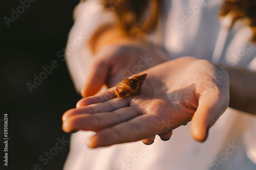 Inhabitants of the sea. The girl holds a sea inhabitant in a shell on her hand. 