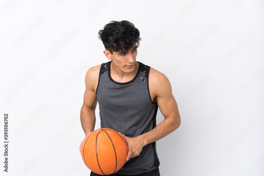 Young Argentinian man over isolated white background playing basketball Young Argentinian man over isolated white background playing basketball