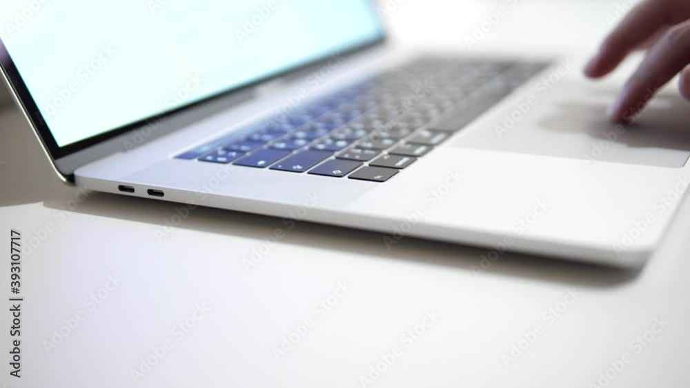 Close-up of men's fingers using laptop touchpad while working in the office or at home. 