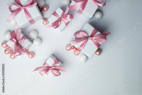 White gifts with pink ribbons. Set of gift box isolated on white background.Christmas gift boxes on white background. Beautiful Christmas background with shiny balls and ribbons in pastel pink color. 