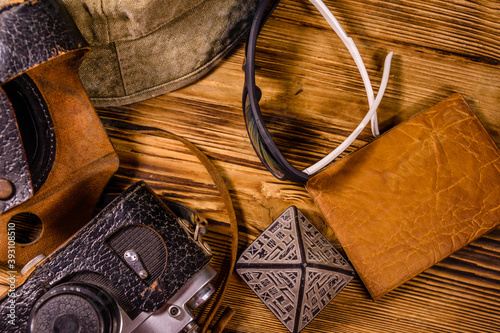 Hipster hat, vintage camera, sunglasses, souvenir pyramid and passport on a wooden background. Travel to Egypt. Top view