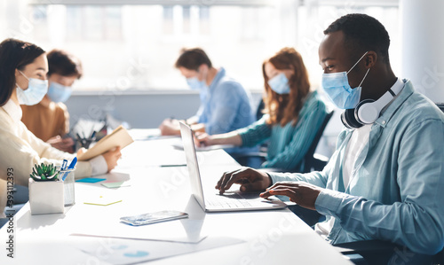 International people wearing medical masks using laptop