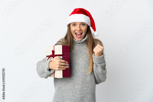 Lithianian woman with christmas hat holding presents isolated on white background celebrating a victory in winner position
