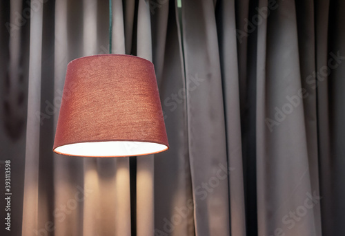 Wallpaper Mural Lamp with a brown fabric lampshade against a background of beige curtains. Torontodigital.ca