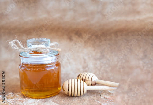 Glass can full of honey and wooden stick