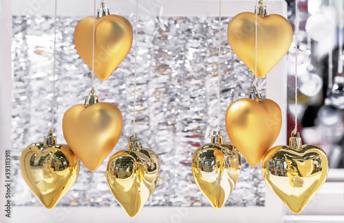 Christmas golden hearts. Glass Christmas decorations in the form of hearts on threads.