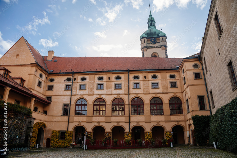 Obraz premium Medieval castle Melnik in sunny autumn day, Courtyard with Renaissance arcades, High clock tower of the Church of Saints Peter and Paul, Central Bohemia, Czech republic