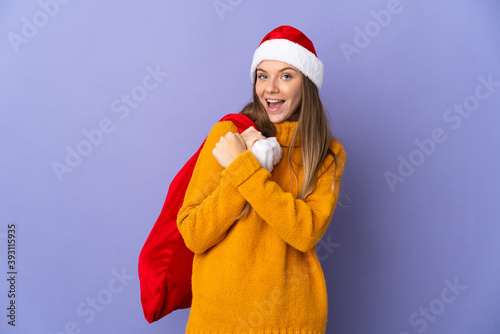 Lithianian woman with christmas hat isolated on purple background celebrating a victory
