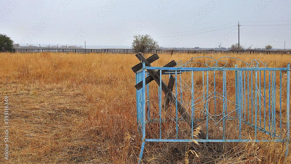 Old rural cemetery in Russia, the fallen cross