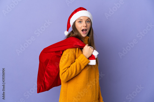 Lithianian woman with christmas hat isolated on purple background with surprise facial expression