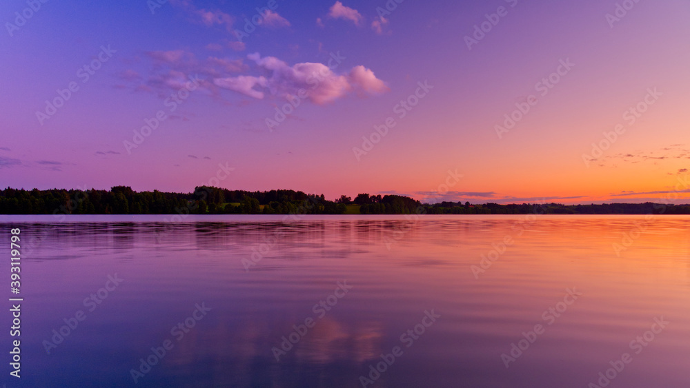 Calm lake with the purple evening sky reflecting.