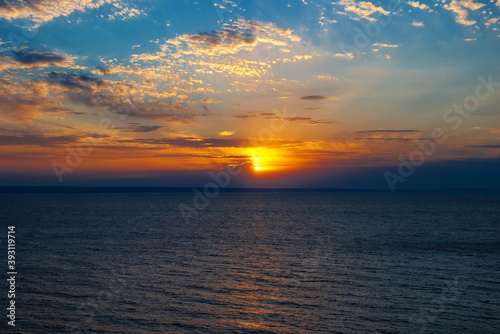 Bright sunset sky with beautiful clouds above water