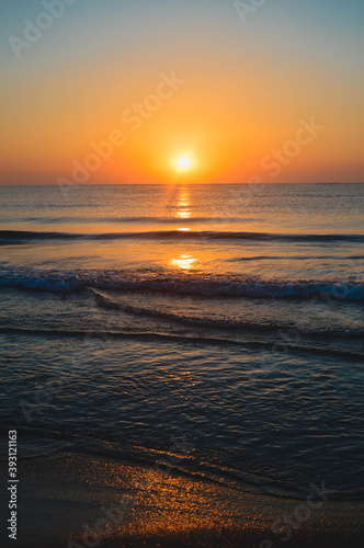 Beautiful summer sunset at the beach, waves and sand