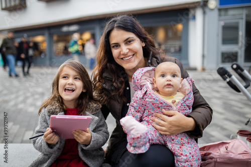 Happy mother smiling and sitting alongside her happy daughters photo