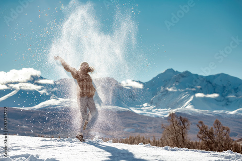 Happy girl tossing powder snow in mountains